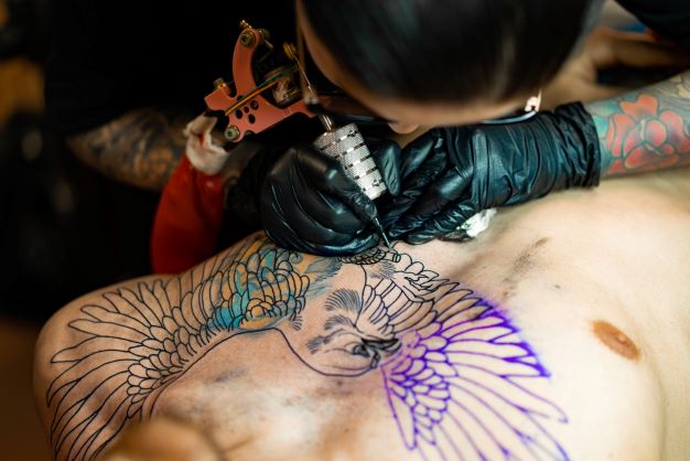 girl-tattooing-wings-chest-area2